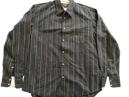 A long-sleeve button-up shirt with vertical pinstripes in black and beige, laid flat on a white fabric background.