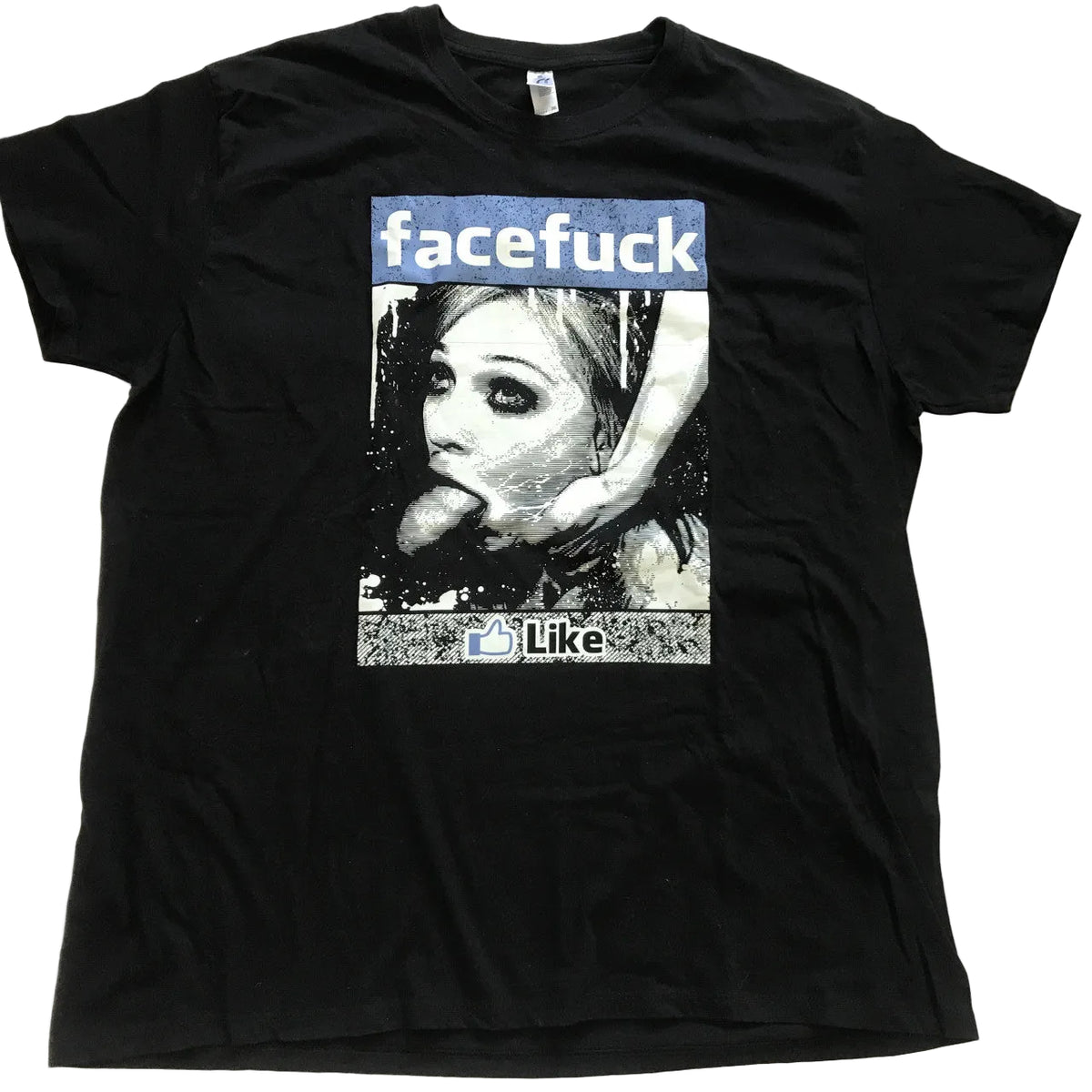 A black short-sleeve graphic t-shirt laid flat on a light-colored fabric background. The graphic features a parody design with the word 'facefuck' in a blue banner above a black-and-white photo of a woman, with 'Like' and a thumbs-up icon below.