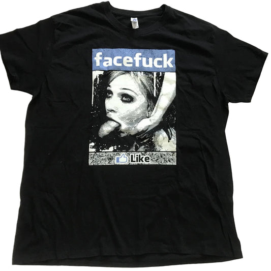 A black short-sleeve graphic t-shirt laid flat on a light-colored fabric background. The graphic features a parody design with the word 'facefuck' in a blue banner above a black-and-white photo of a woman, with 'Like' and a thumbs-up icon below.